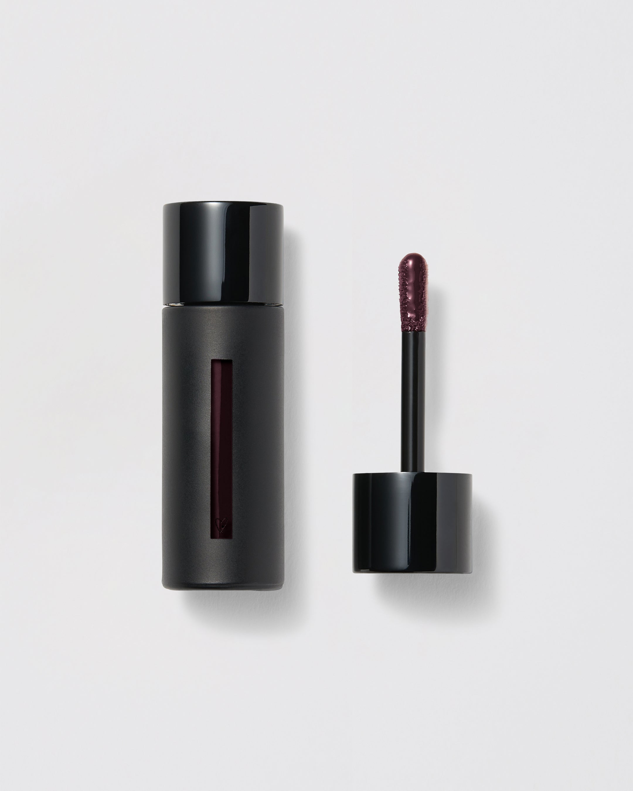Black lip gloss container with applicator on a gray background
